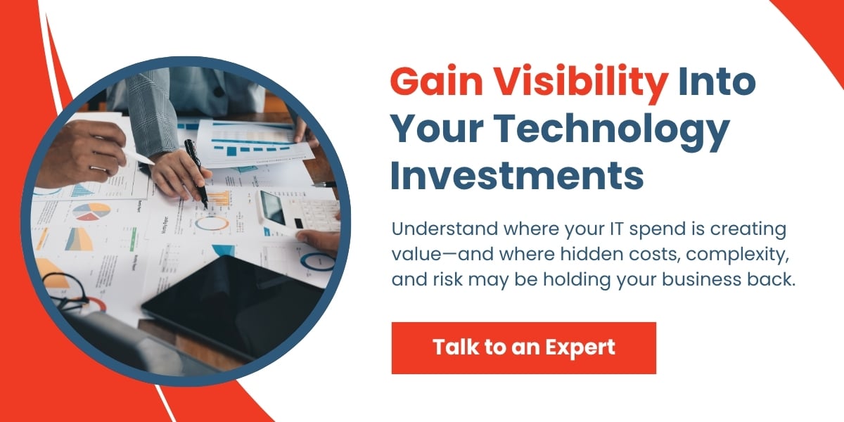 Professionals reviewing technology reports, charts, and analytics documents during a strategic IT investment planning meeting.